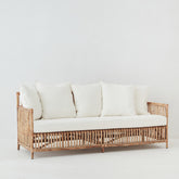 Lene Rattan Sofa with cream cushions – side view